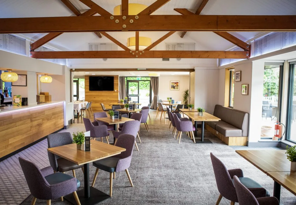 Event space with wooden beams and tables at Wycombe Heights, a venue for events High Wycombe