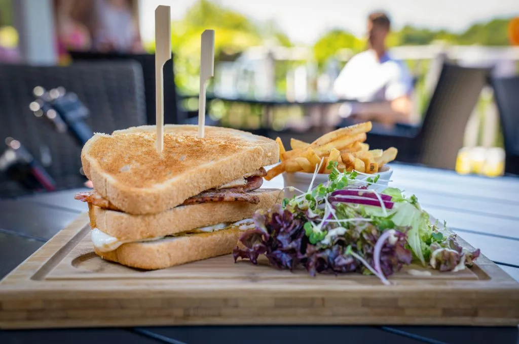 Plate with sandwich, salad, and chips served at Wycombe Heights Golf Club restaurant in High Wycombe